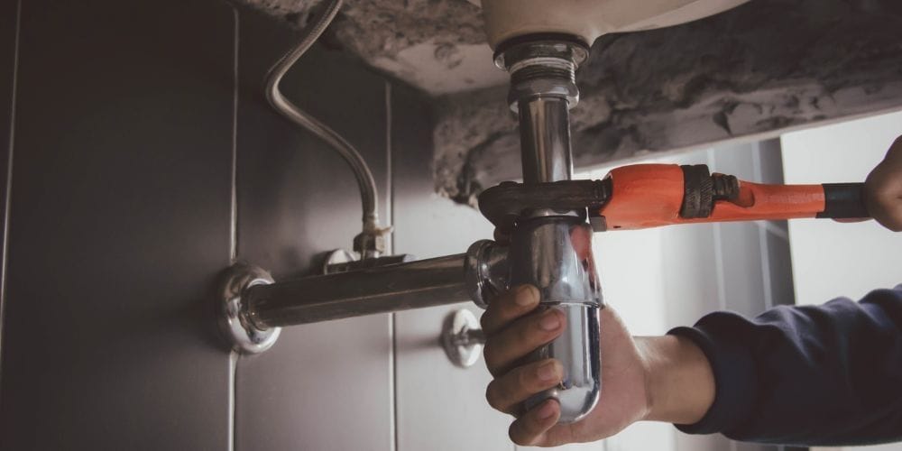 Plumber fixing a leaky pipe.