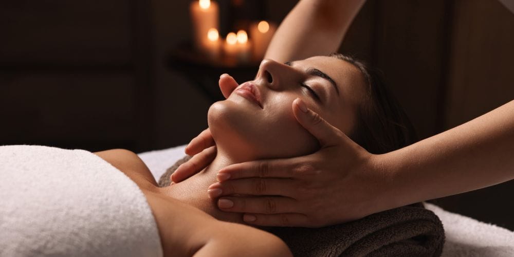 Woman receiving a facial massage at a day spa.